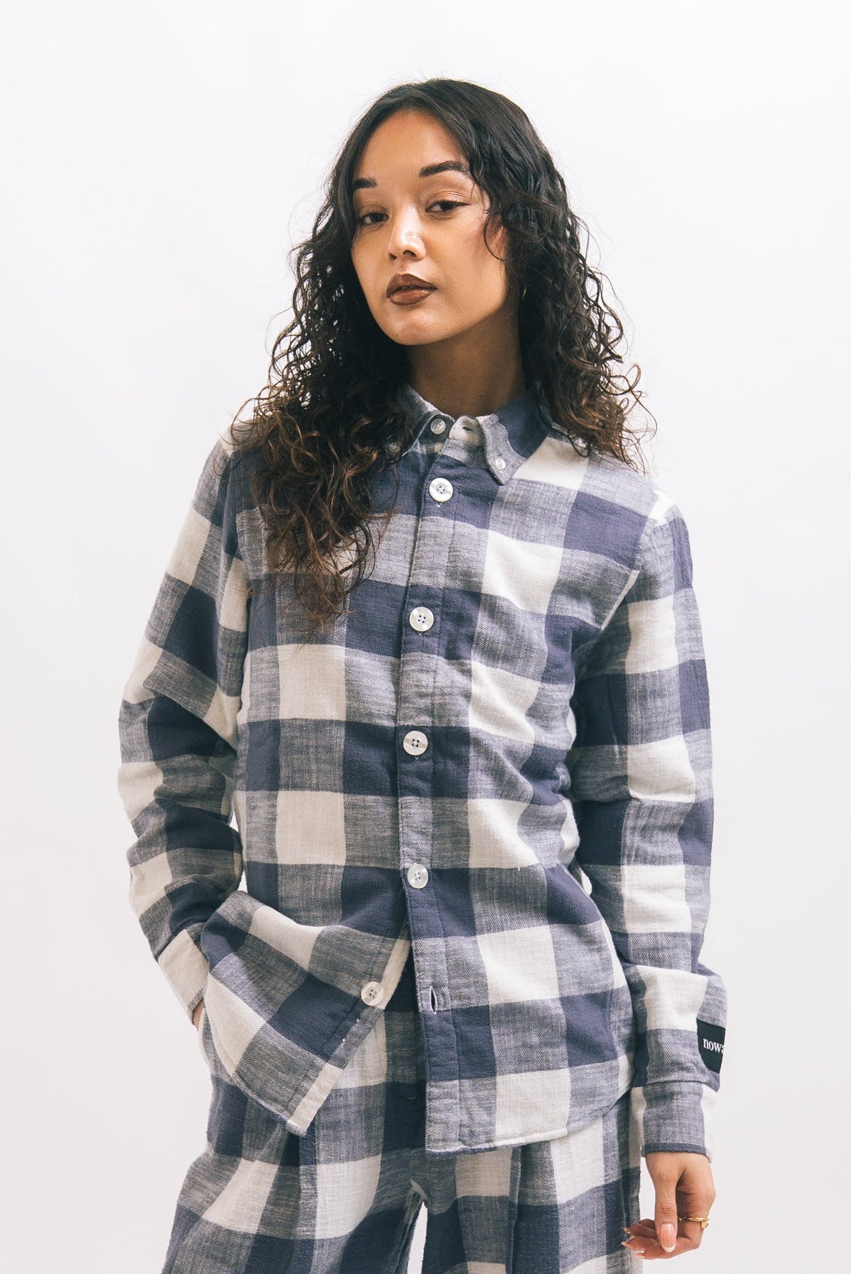 Person wearing a blue and white checkered outfit on a white background
